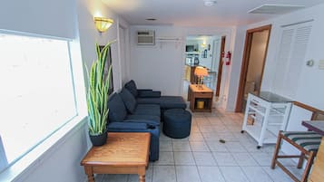 Una sala de estar con un sofá modular, una mesa de centro de madera y una planta en maceta.