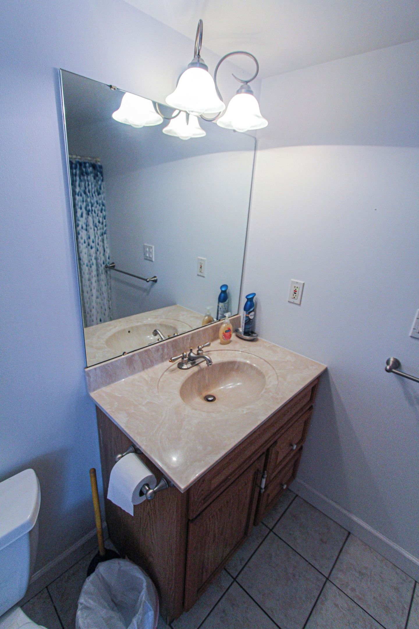 A bathroom with a sink, mirror, and overhead lights.
