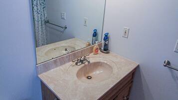 A bathroom with a sink, mirror, and overhead lights.