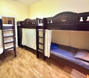 A room with bunk beds, wooden headboards, and a simple layout. - Homeland Female Hostel (Dubai)