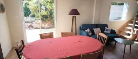 A dining area with a round table and chairs, a sofa, and a lamp.