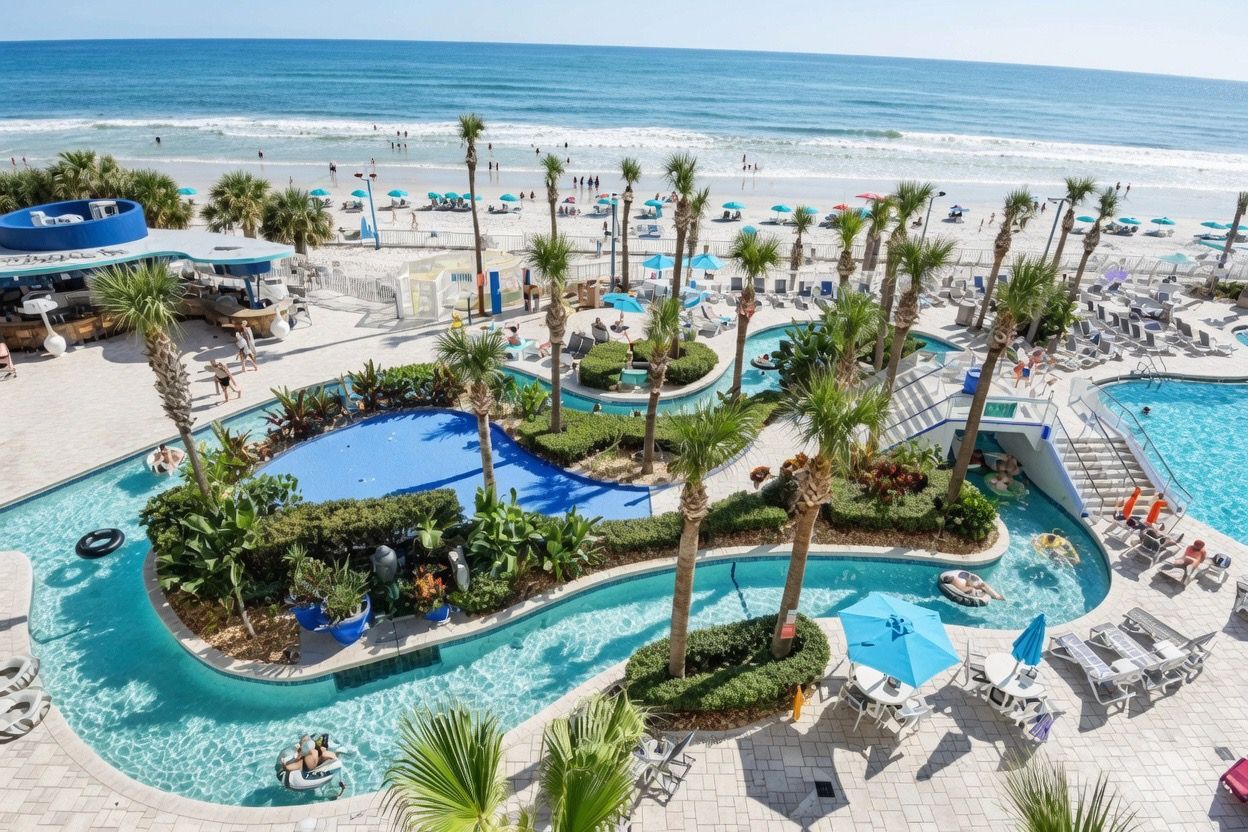 A resort pool area with multiple swimming pools, lounge chairs, and palm trees.