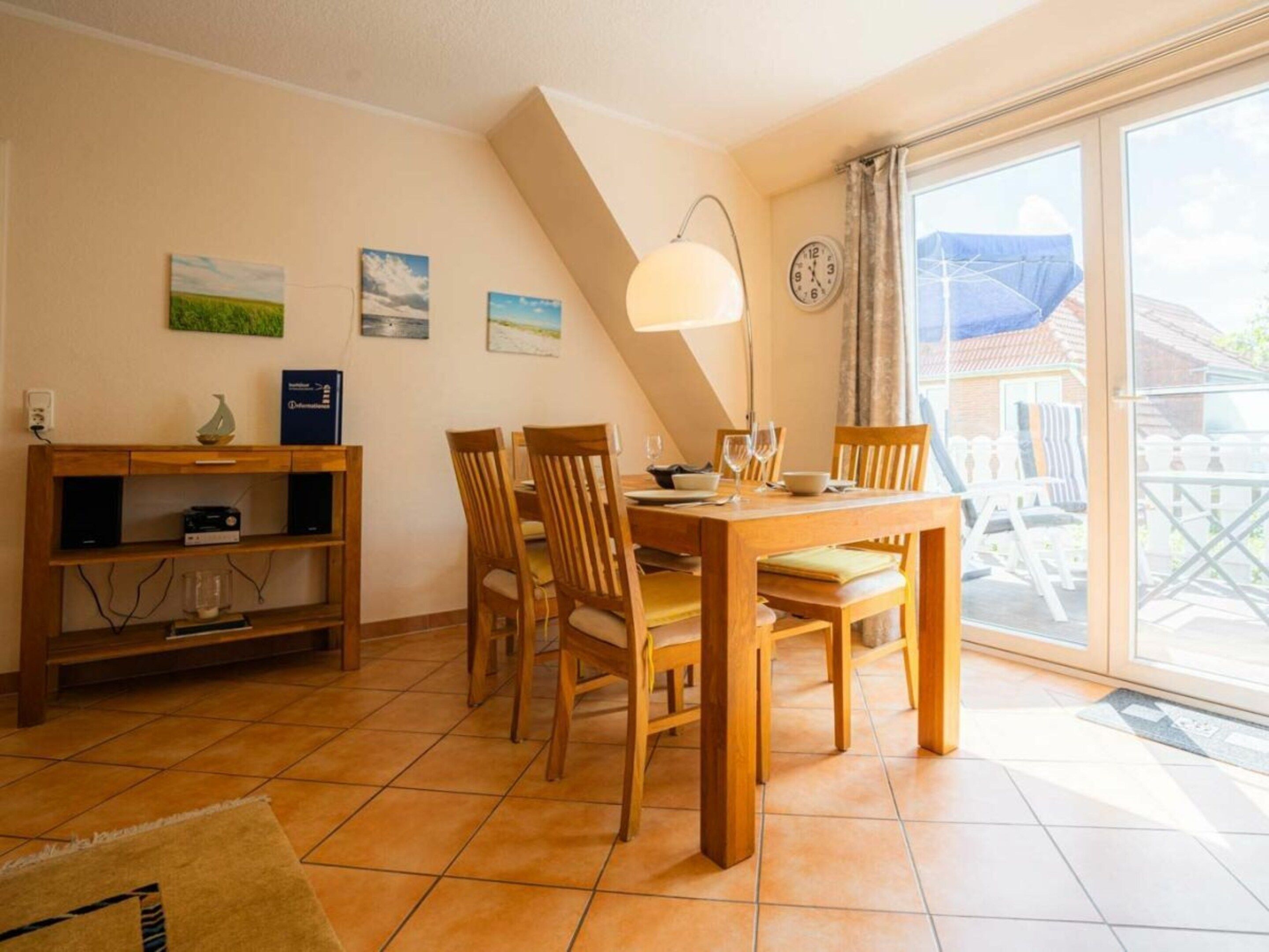 Un coin repas avec une table et des chaises, une bibliothèque et une fenêtre donnant sur l’extérieur.