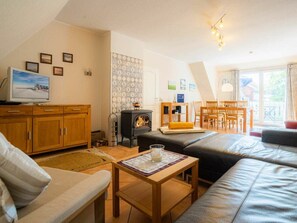 Ein gemütliches Wohnzimmer mit Kamin, Fernseher und Essbereich.