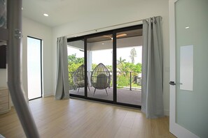 A room with a sliding glass door leading to an outdoor seating area with two chairs. - *New* Naples Villa w/ Pool Jacuzzi | Sleeps 14 (Naples)