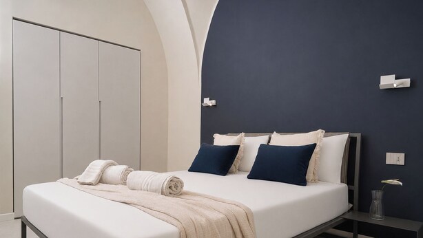 Una camera da letto moderna con un letto, comodini e un armadio.