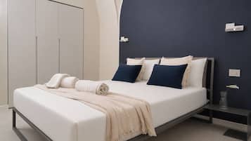 Een moderne slaapkamer met een bed, nachtkastjes en een kledingkast.