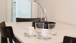 Un tavolo da pranzo con un vaso, due tazze e due bicchieri.