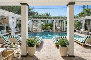 A poolside area with lounge chairs, a pool, and a pergola with plants. - Coastal Cabana• Private Pool• Ocean View• Near 30A (Panama City Beach)