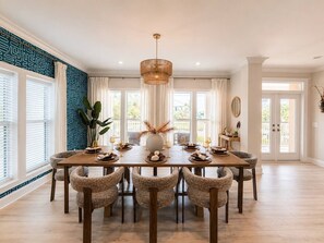 A dining area with a round table, six chairs, and a chandelier. - Coastal Cabana• Private Pool• Ocean View• Near 30A (Panama City Beach)