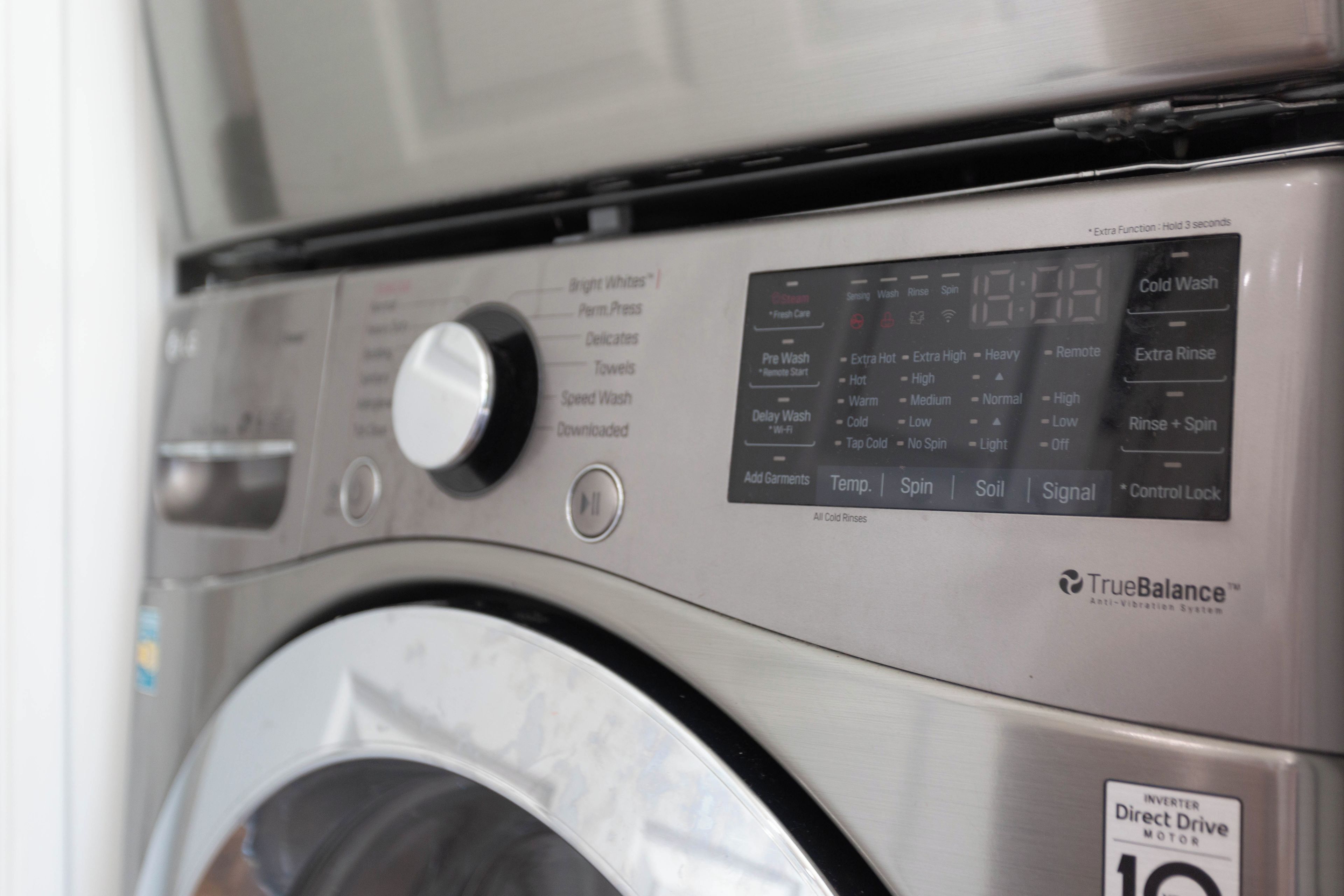 Een wasmachine met een bedieningspaneel met verschillende wasprogramma’s en een TrueBalance™ trillingsabsorberend systeem label.