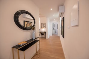 A hallway with a console table, a mirror, and artwork on the walls. - House Giotto 33 (Firenze)