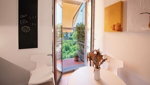 A modern bathroom with a white sink, a blackboard with writing, and a view of a balcony with greenery. - House Giotto 33 (Firenze)