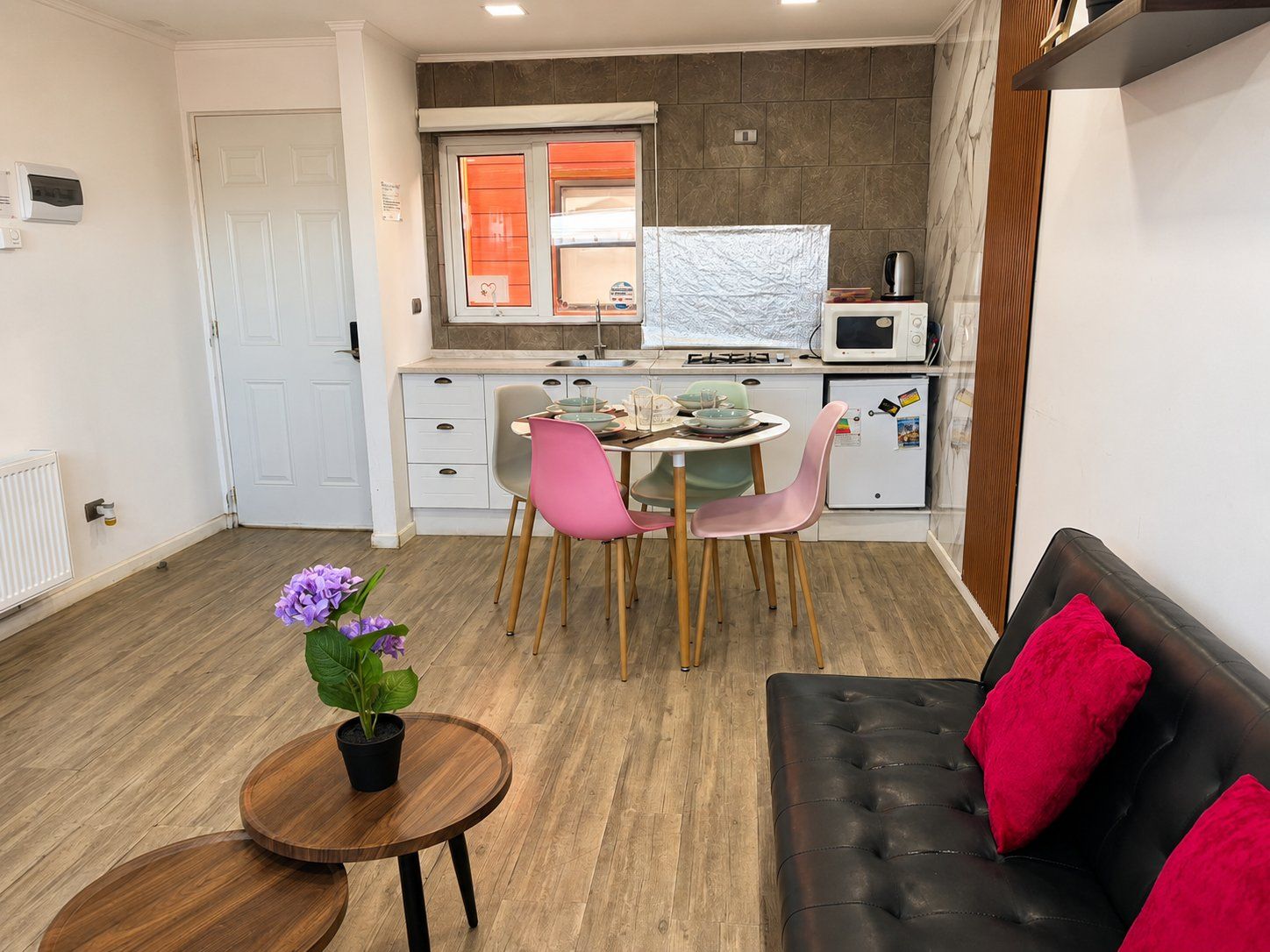 A compact living space with a kitchenette, a dining area, and a seating area.