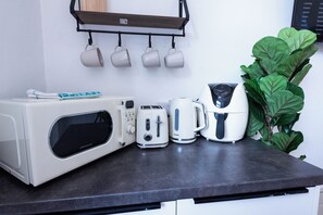 A kitchenette with a microwave, toaster, and coffee maker on a countertop. - The Stanley Arms Hotel by Guestz (Seascale)