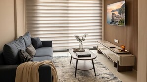 Un salon moderne avec un canapé, une table basse et un téléviseur fixé au mur.