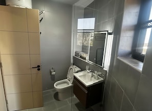 Un baño moderno con inodoro, bidé y lavamanos.