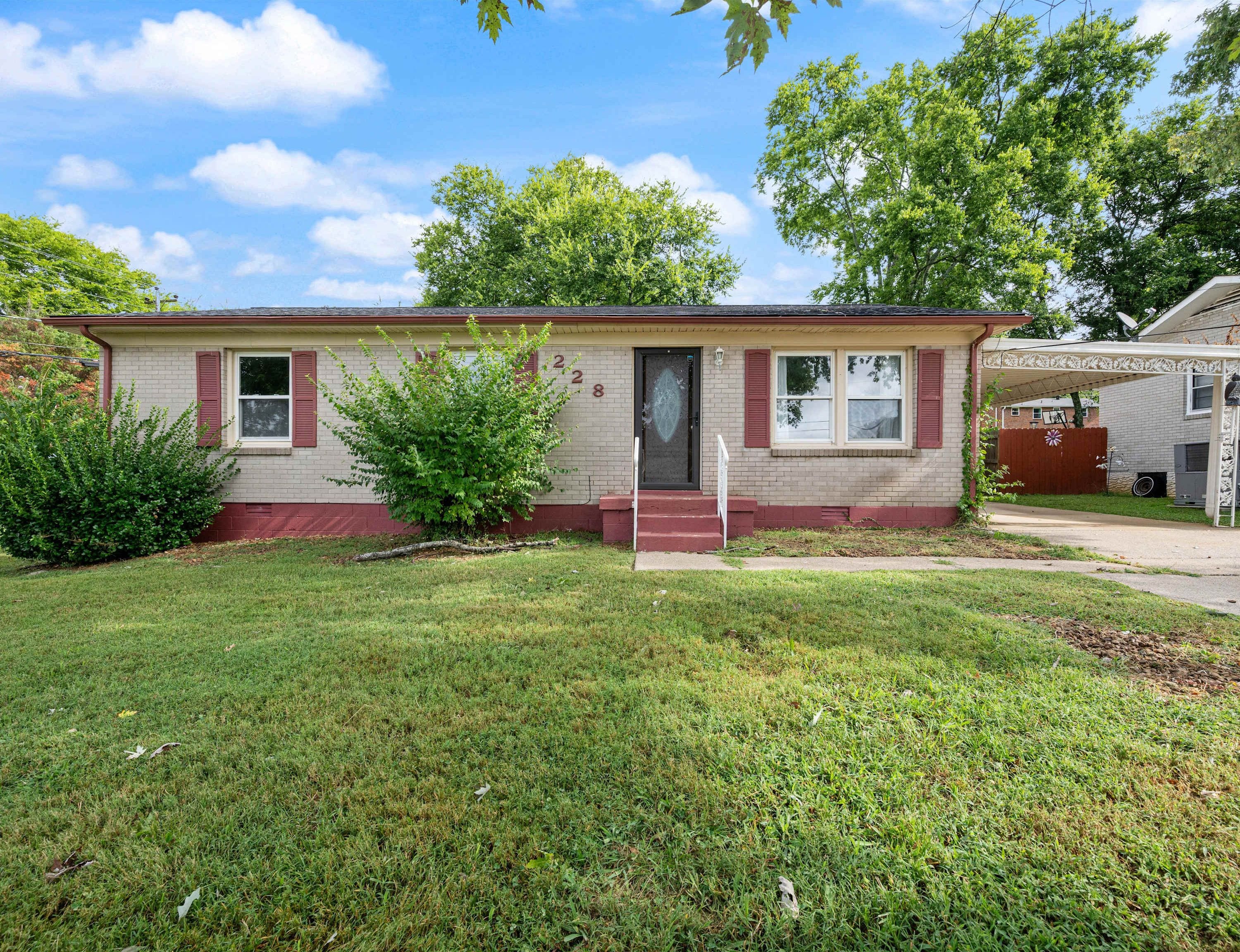 A single-story house with a front porch, a small front yard, and a garage.