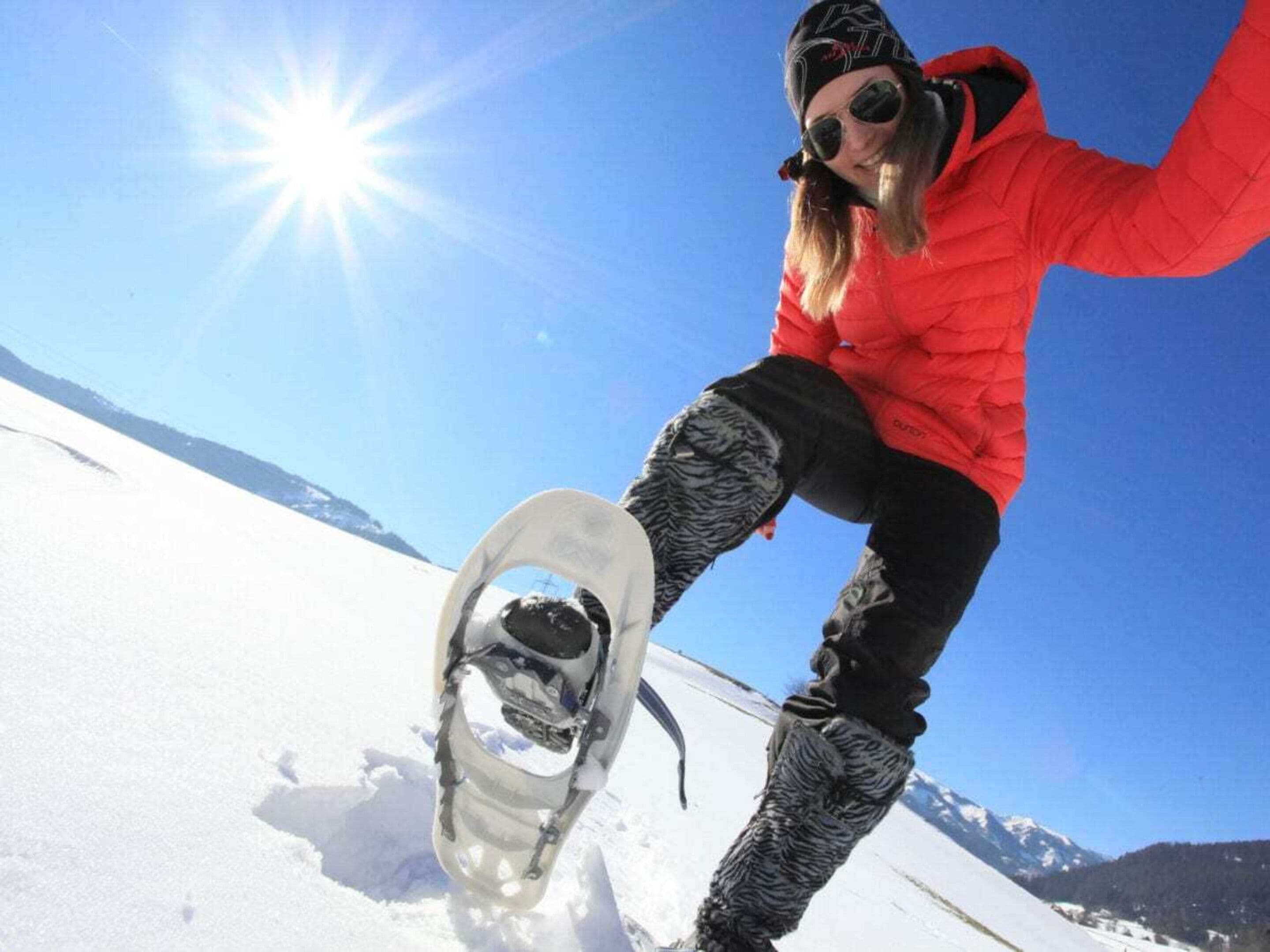 A person snowboarding on a snowy slope with a clear sky.
