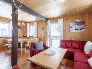Ein gemütliches Blockhaus-Interieur mit einer Holzeinrichtung, einem roten Sofa und einem Holztisch.