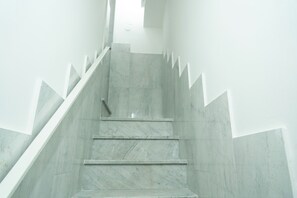 Un escalier au design moderne, avec un revêtement en marbre et des motifs géométriques sur les murs.