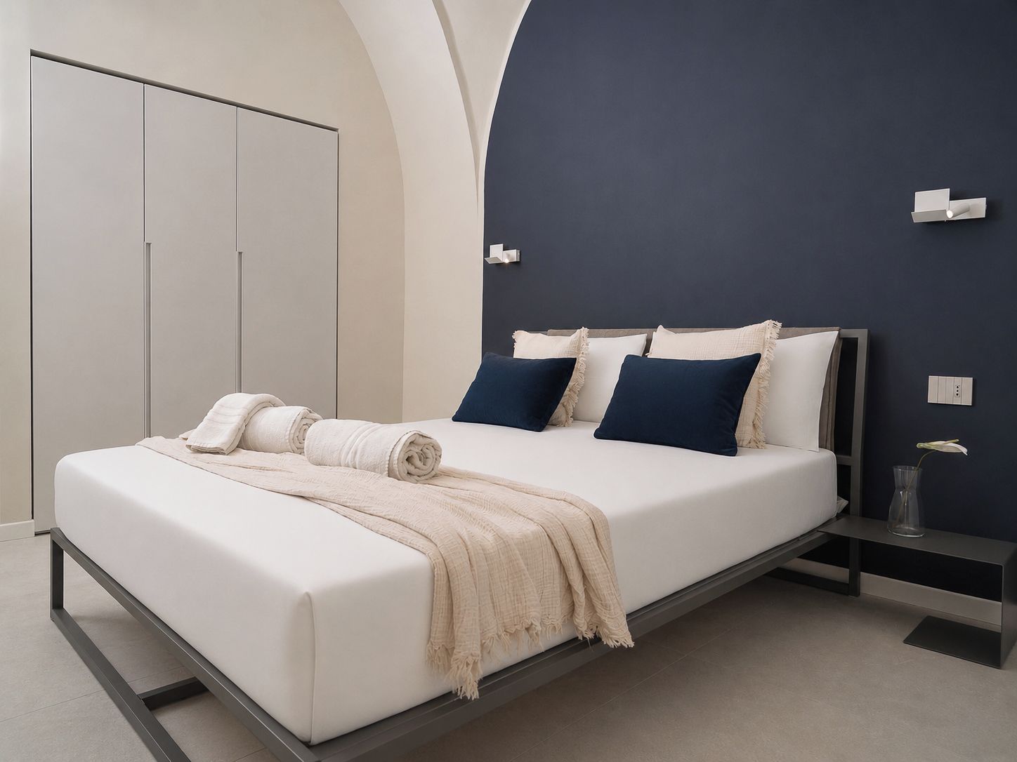 Un dormitorio moderno con cama, mesitas de noche y un armario.