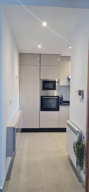 Cozinha moderna com eletrodomésticos embutidos, bancada e radiador.