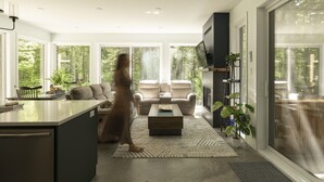 Un salon moderne avec un canapé, une table basse et un téléviseur fixé au mur.