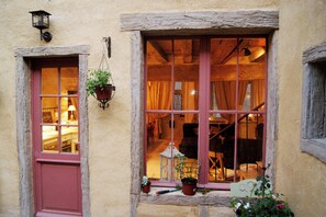 A building with a large window, a door, and a hanging light fixture. - Vrbo Property (Sancerre)