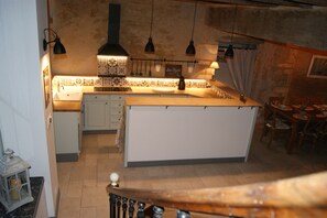 A kitchen with a central island, hanging pendant lights, and a tiled backsplash. - Historic House in the Heart of Sancerre – Wines, Restaurants, and the Village Within Walking Distance (Sancerre)