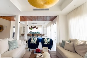 Uma sala de estar moderna com um sofá, mesa de centro e área de jantar com mesa e cadeiras.