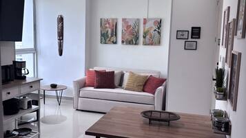 Ein modernes Wohnzimmer mit einem weißen Sofa, einem Holzespeisetisch und einem Deckenventilator.