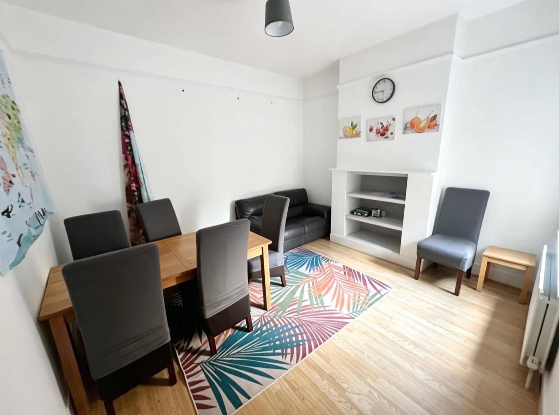 Ett modernt vardagsrum med ett matbord, soffor och en TV-bänk.