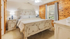 A bedroom with a bed, bedside tables, a ceiling fan, and a window with curtains. - HunnyBear Hideout on Cedar Creek Lake (Eustace)