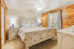A bedroom with a bed, bedside tables, a ceiling fan, and a window with curtains. - HunnyBear Hideout on Cedar Creek Lake (Eustace)