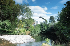 A riverside view with a building labeled 'Stanley Arms Hotel' in the background. - The Stanley Arms Hotel by Guestz (Seascale)