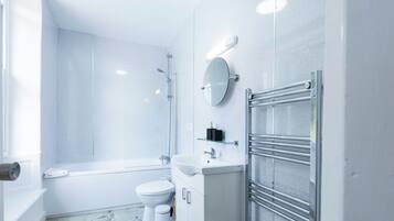 A modern bathroom with a bathtub, toilet, and sink.