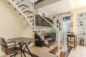 Eine moderne Küche mit einer gläsernen Wendeltreppe, die in einen Essbereich führt.