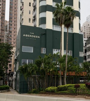 Un immeuble à plusieurs étages, doté d’une façade verdoyante et sur lequel on peut lire le nom « THE ABERDEEN BY OVOLLO ».