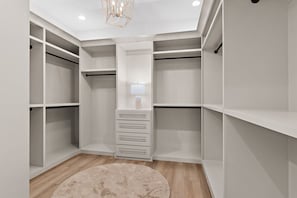 A walk-in closet with multiple shelves, a central storage unit, and a hanging rod. - Pet Friendly | Bikes | Golf Cart | Private Pool | Spotted Dolphin (Santa Rosa Beach)