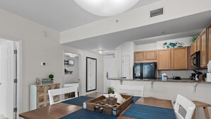 A modern kitchen with wooden cabinets, a black refrigerator, and a countertop with various appliances and items. - 🌴Beach Nearby + Lagoon Pool | Fab Amenities | Palms Resort 1404☀️ (Destin)