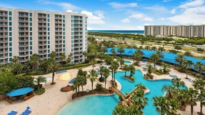 A resort with a large pool area, multiple buildings, and a beach view. - 🌴Beach Nearby + Lagoon Pool | Fab Amenities | Palms Resort 1404☀️ (Destin)