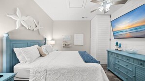 A bedroom with a bed, a ceiling fan, a wall-mounted TV, and a dresser. - 🎣Angler Dock House | Private Pool | Lagoon View | Close to Beach🌊 (Panama City Beach)