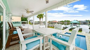 A covered outdoor area with a pool, seating, and a view of a body of water. - 🎣Angler Dock House | Private Pool | Lagoon View | Close to Beach🌊 (Panama City Beach)