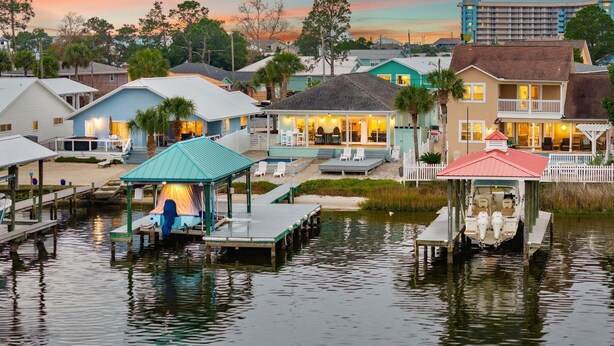 A waterfront property with multiple houses, docks, and a pier. - 🎣Angler Dock House | Private Pool | Lagoon View | Close to Beach🌊 (Panama City Beach)