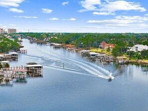 En flod med en båd, der laver en kølvand, omgivet af både broer og bygninger.