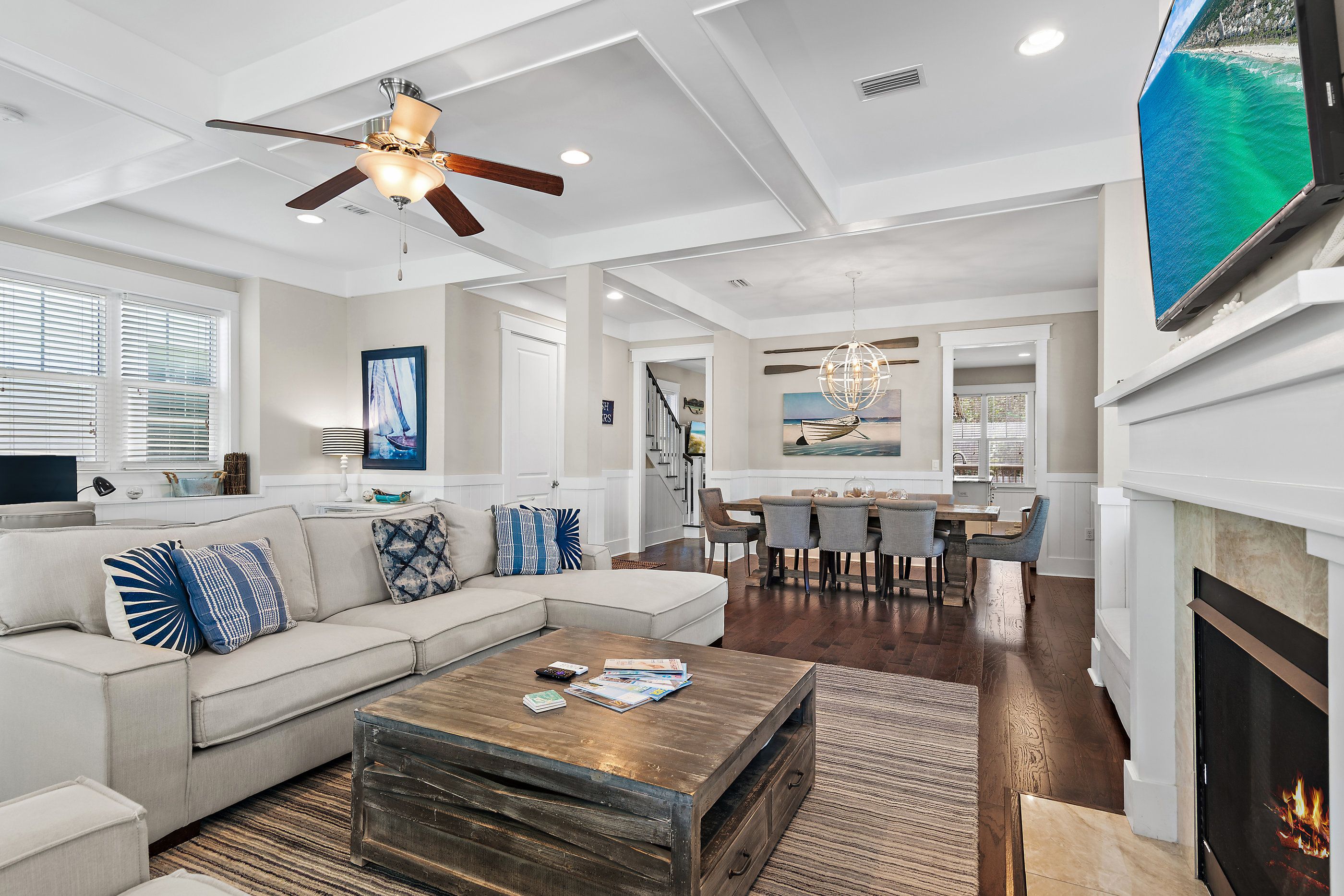 A modern living room with a sectional sofa, a coffee table, and a fireplace.