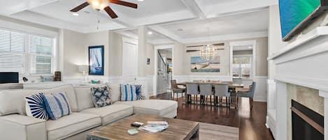 A modern living room with a sectional sofa, a coffee table, and a fireplace.