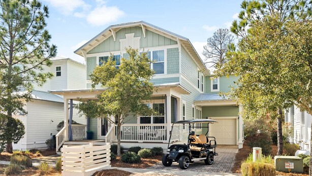 A two-story house with a porch, a covered driveway, and a golf cart parked in front. - 🌴Sea Esta | 4BR Coastal Retreat | Golf Cart + 6 Bikes | NatureWalk🌴 (Santa Rosa Beach)