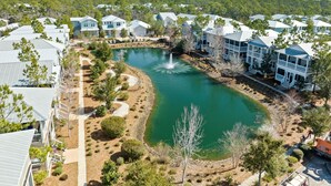A residential area with houses, a pond, and a fountain. - 🌴Sea Esta | 4BR Coastal Retreat | Golf Cart + 6 Bikes | NatureWalk🌴 (Santa Rosa Beach)